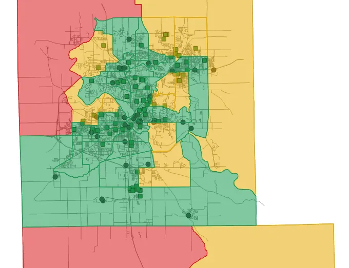 A map of Cedar Rapids census tracts shaded green, yellow and red, with dark green round station markers and square shelter markers clustered in the center of the city.